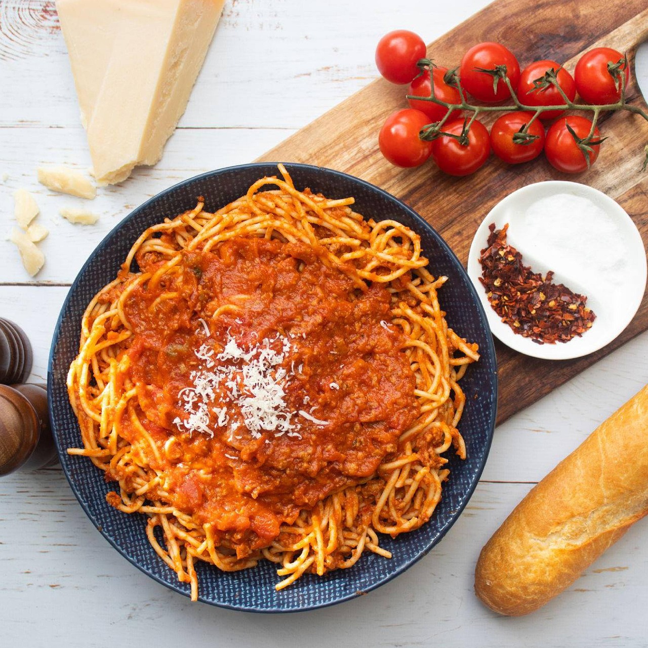 Assiette de spaghetti nappés d'une sauce bolognaise maison à la tomate et à la viande mijotée, avec parmesan râpé